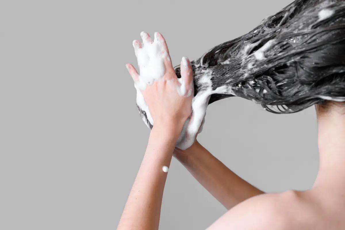 Kobieta myjąca włosy szamponem z piwa